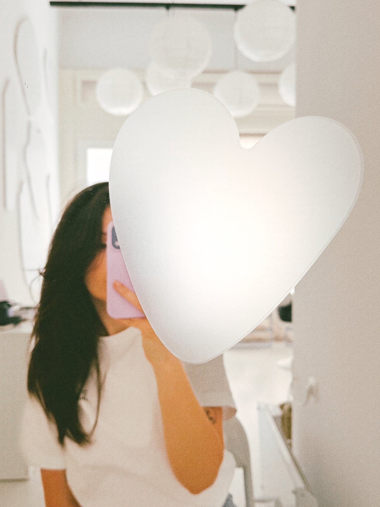 Ana in the studio mirror, behind a white heart